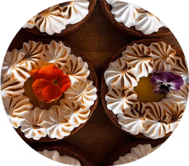 small cakes with burned cream and eatable flowers on top
